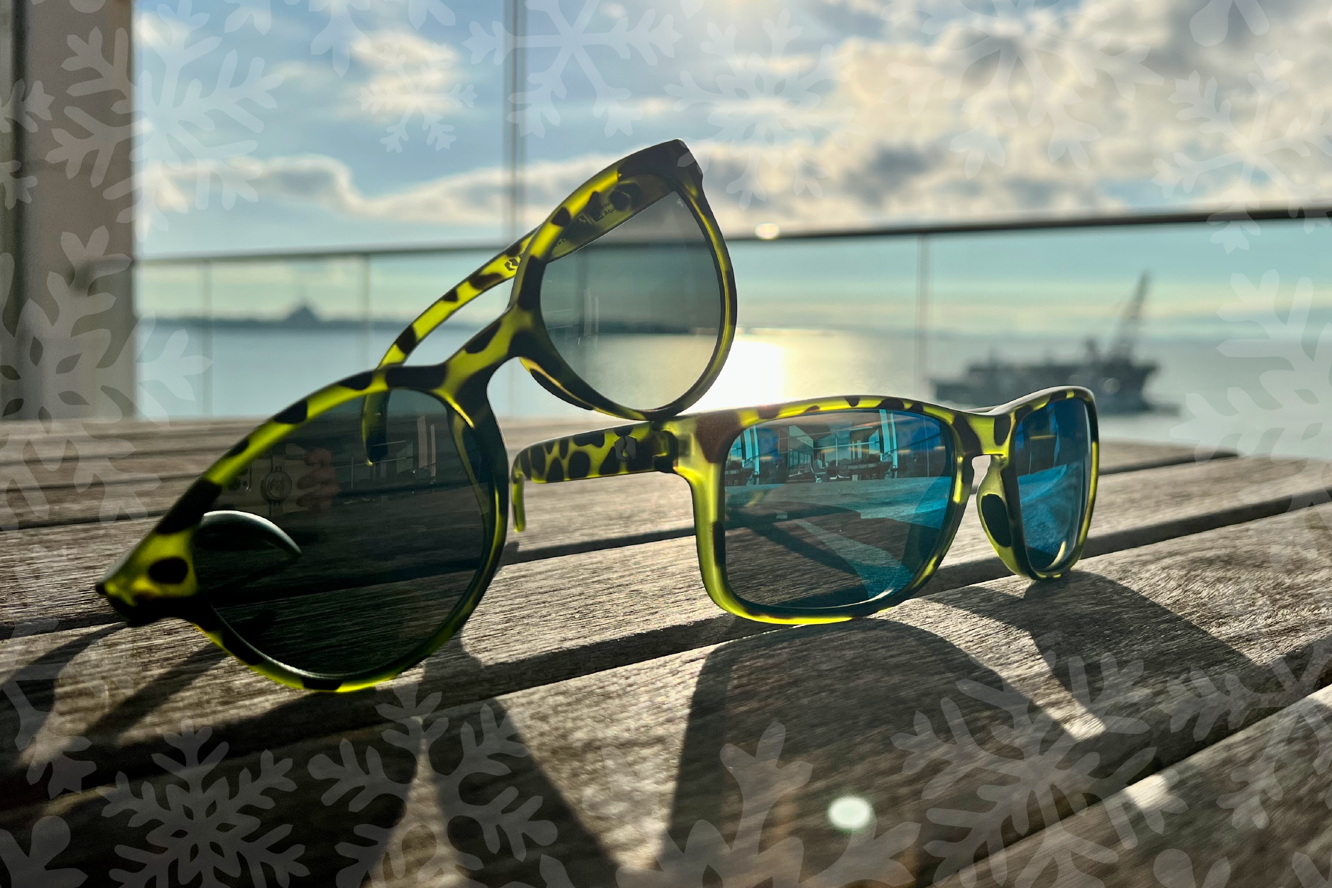 Rheos green tortoise shell sunglasses sit on a wooden table in the sun