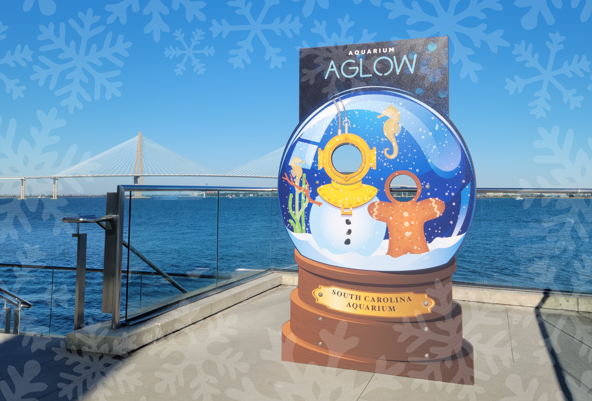 A photo station in front of the Charleston Ravenel Bridge looks like a snowglobe with a snowman and gingerbread man