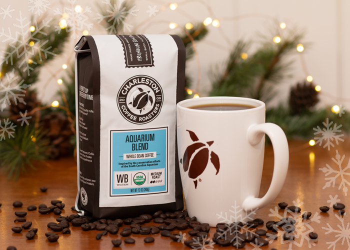 holiday CCR 2022 A bag of Charleston Coffee Roasters Aquarium Blend sits next to a coffee mug with a sea turtle on it in front of holiday lights.